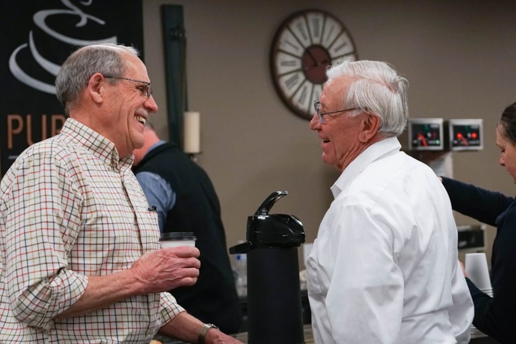 Two older friends talking together over coffee
