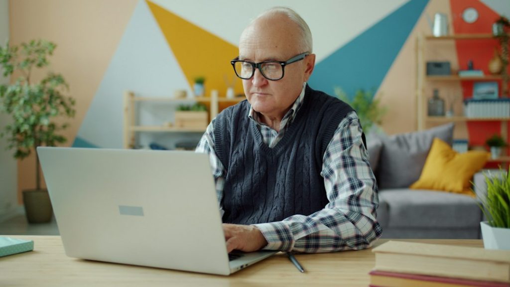 Mature man using a laptop at home